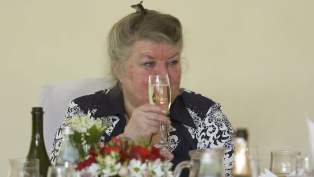 Mujer-Senior-en-mesa-festiva.-Adultos-mayores-celebran-70-cumpleaños