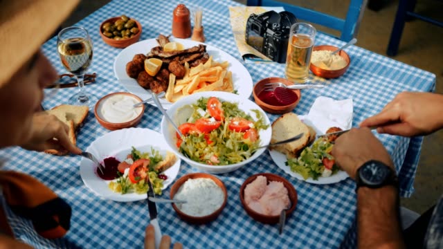 Pareja-de-jóvenes-turistas-almorzando-en-el-restaurante-griego-tradicional