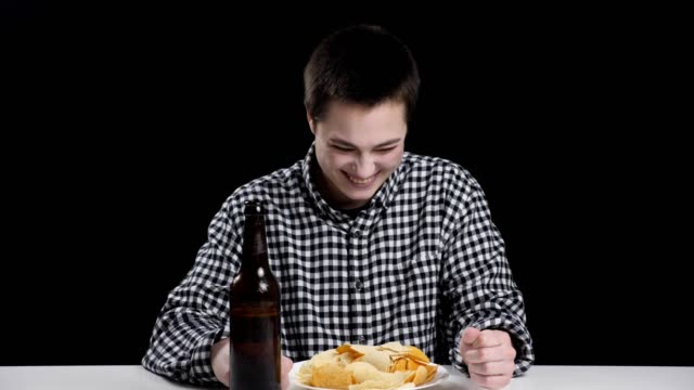 Joven-Varonil-terminó-comiendo-patatas-fritas-y-bebiendo-cerveza,-sonriendo,-riendo,-dieta-concepto,-negro,-Fondo