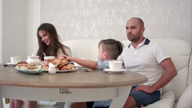 Glückliche-Familie-zusammen-beim-Frühstück-auf-den-Tisch-im-Restaurant-zu-spielen
