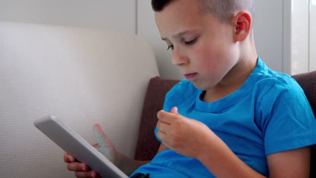 Süsser-Boy-Cornflakes-zu-essen,-während-des-Spielens-auf-tablet