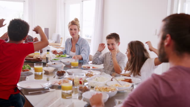 Zwei-Familien-genießen-Mahlzeit-im-Hause-zusammen-Schuss-In-Zeitlupe