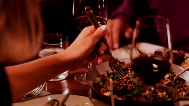 Primer-plano-de-gente-comiendo-ensalada-de-quinoa-gourmet-en-restaurante-de-lujo