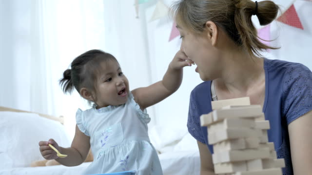 4K-:-Happy-Asian-child-feeding-potato-chips-for-her-mother