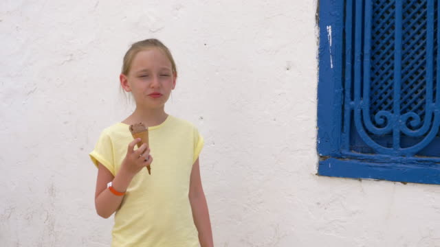 Porträt-Mädchen-Teenager-essen-Schokolade-Eis-auf-weiße-Wand-Hintergrund