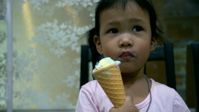 Kid-is-eating-rainbow-ice-cream-cone.