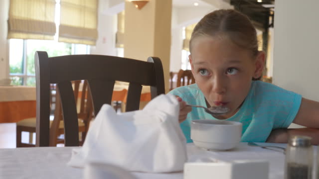 Chica-adolescente-de-retrato-comer-gachas-de-avena-en-el-desayuno-de-la-mañana-en-el-restaurante-del-hotel