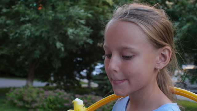 Close-up-girl-teenager-eating-ice-cream-and-licking-lips-in-summer-park