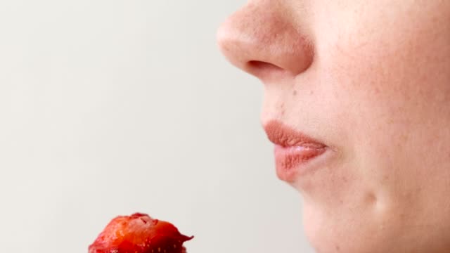 Woman-eats-strawberries.-Mouth-close-up.-Side-view.