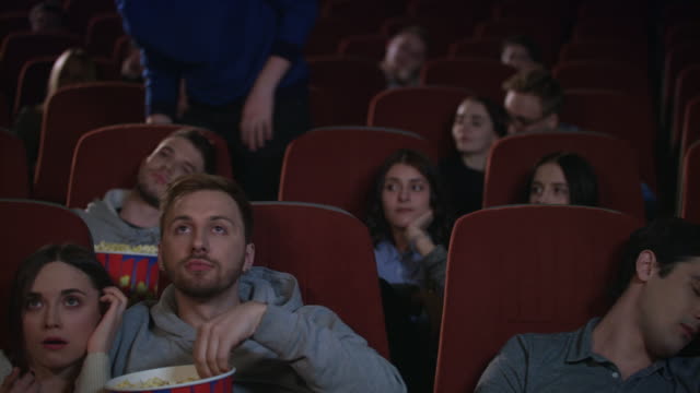 Público-aburrido-salir-cine-mientras-sesión-en-cámara-lenta.-Película-Uninteresting