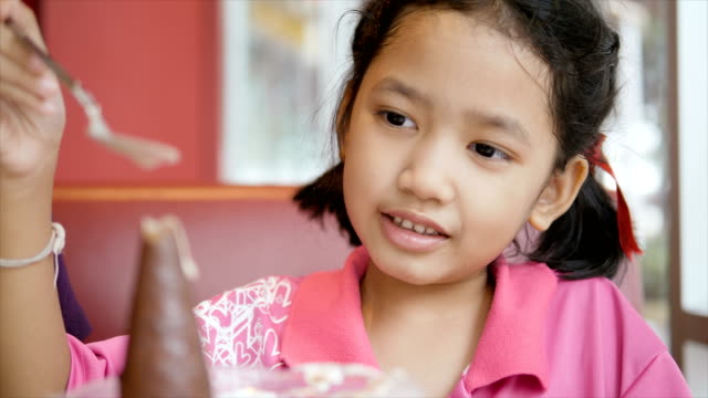 Slow-motion-Asian-little-girl-is-eating-ice-cream-with-happiness