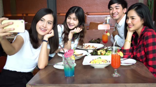 Junge-asiatische-Menschen-Selfie-fotografieren-und-einem-gemeinsamen-Mittagessen-im-Restaurant-während-sie-Posen-ständig
