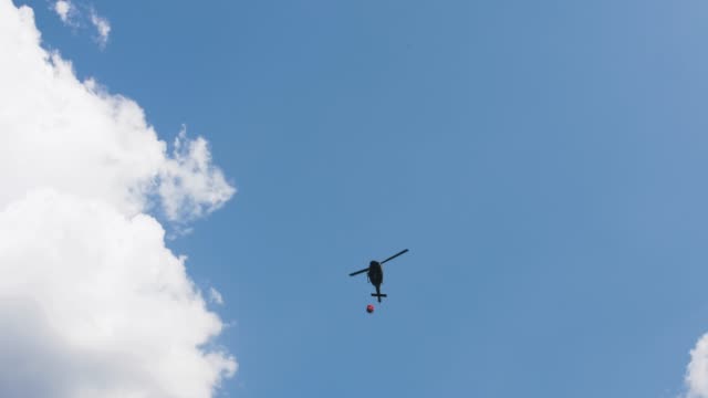 HALLSTATT,-AUSTRIA---22-de-agosto-de-2018-helicóptero-toma-agua-en-el-lago-para-combatir-el-incendio-en-las-montañas