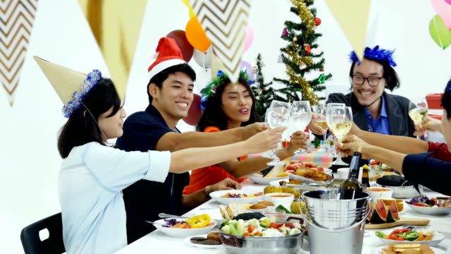 Gruppe-von-Asiaten-mit-Abendessen-an-Silvesterparty-zusammen.-Menschen-sitzen-um-ein-Tisch-und-Essen-zusammen.-Menschen-mit-Silvester-Party-Konzept.