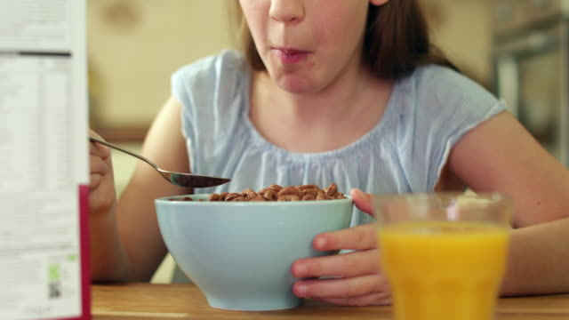 Nahaufnahme-von-Mädchen-essen-ungesund-Schale-mit-zuckerhaltigen-Frühstücksflocken-In-Küche