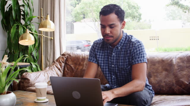 Junge-Hispanic-Mann-mit-Laptop-in-einem-Café