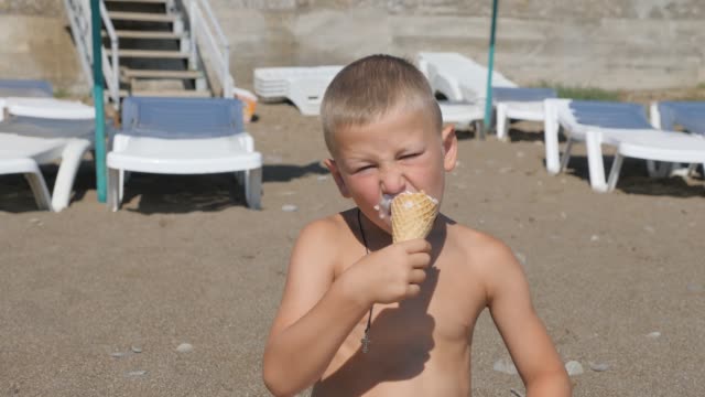 Child-eats-ice-cream.-boy-smeared-his-face-with-food.-Kid-eats-ice-cream-from-a-waffle-cone.