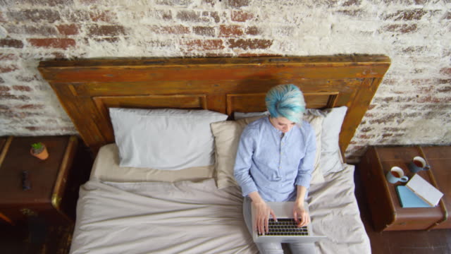 Hipster-Woman-Sitting-on-Bed-and-Working-on-Laptop