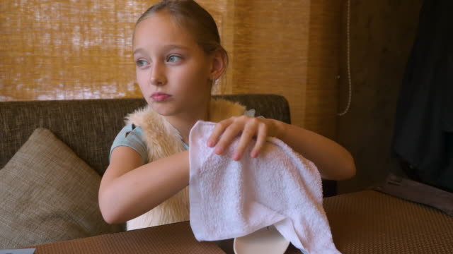 Chica-joven-sentado-en-la-mesa-de-café-y-limpiar-sus-manos-con-una-toalla-mojada-y-preparándose-para-comer-sushi.