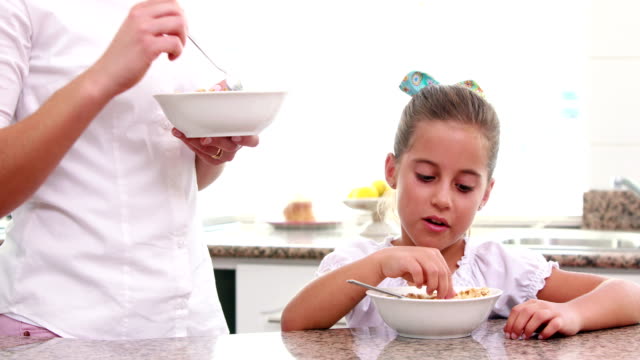 Mother-and-her-daughter-eating-cereals-together