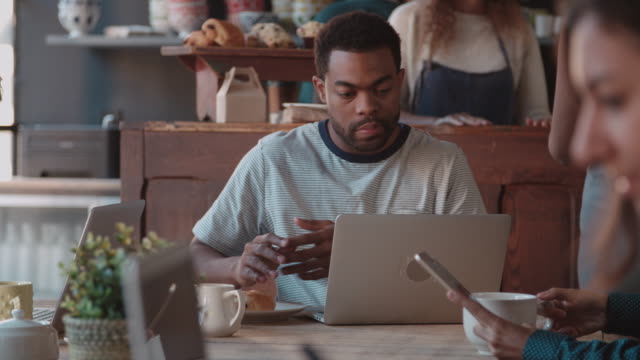 Hombre-cliente-en-la-tienda-de-café-utilizando-ordenador-portátil-en-el-escalofriante-R3D