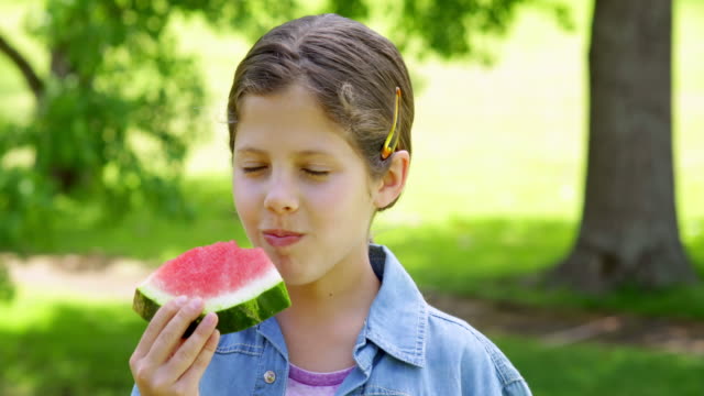 Niedliche-kleine-Mädchen-Essen-Wassermelone-in-der-park