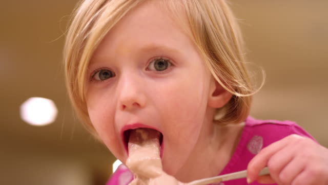 Close-up,-young-girl-eating-ice-cream,-slow-motion