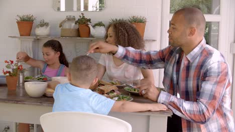 Family-At-Home-Eating-Meal-On-Outdoor-Verandah-Together