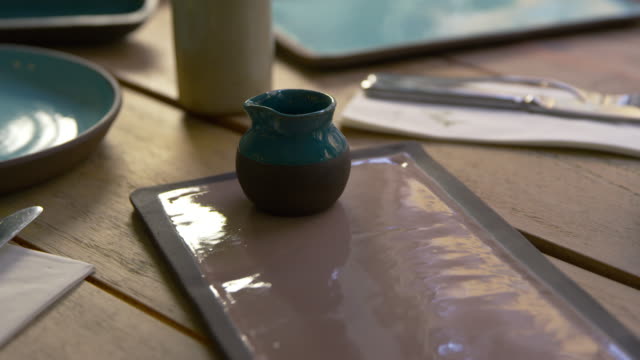 Handmade-earthenware-on-restaurant-table,-camera-slider-shot
