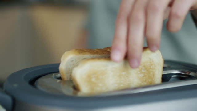 Nahaufnahme-einer-Frau-nehmen-Toast-aus-einem-Toaster.
