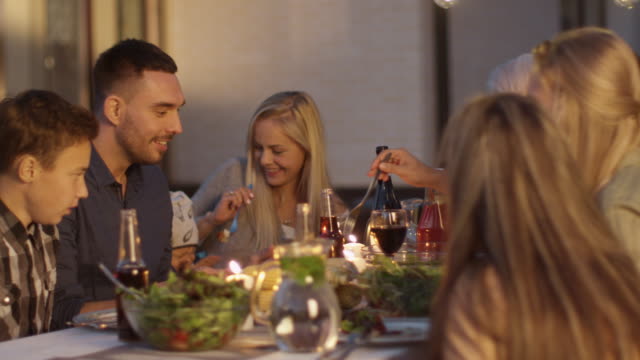 Gruppe-der-Mixed-Rennen-Menschen-Spaß,-Kommunizieren-und-Essen-beim-Outdoor-Family-Dinner