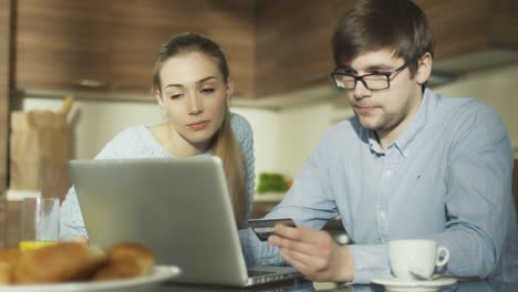 Ehepaar-nutzt-Laptop-für-Online-Shopping-zu-Hause