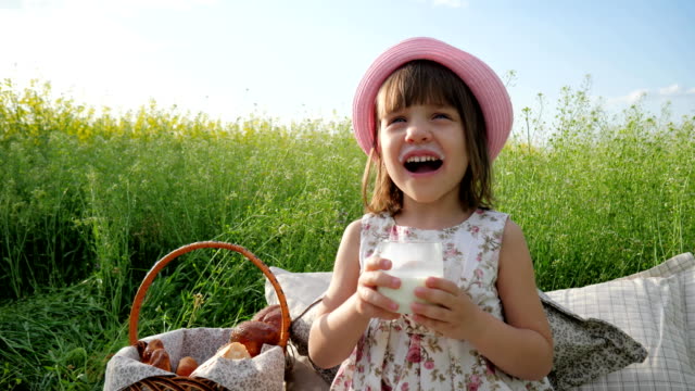Pleasure-on-child's-face,-milk-advertising,-Healthy-food-for-children,-little-female-child-at-picnic-drinks,-dairy-products,-healthy-kid-drinks