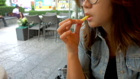 young-woman-eating-french-fries