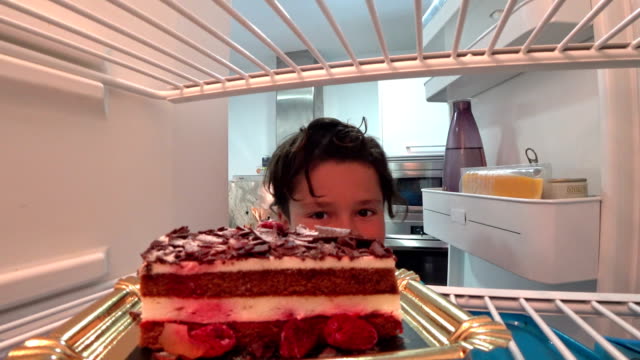 Niño-hambriento-comiendo-pastel-de-refrigerador