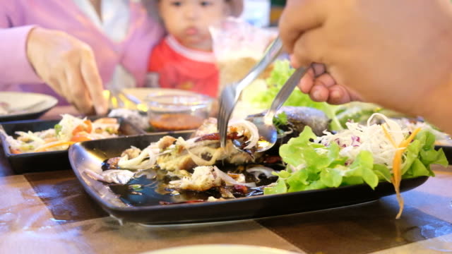 Hand-schöpfen-Salat-Fisch-Essen-am-Tisch-mit-Familie