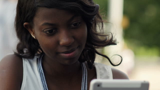Stilvolle-schwarze-weibliche-Frau-arbeiten-mit-modernen-Tablet-im-Freien-im-Sommer-Stadt