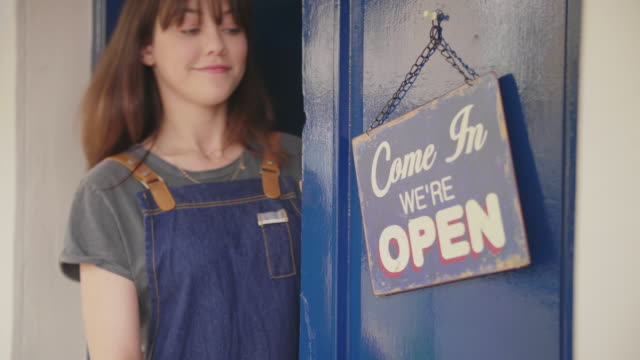 Deli-Owner-Turning-Sign-From-Open-To-Closed-On-Door