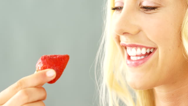Nahaufnahme-der-schönen-Frau-in-Schüssel-Erdbeeren-essen