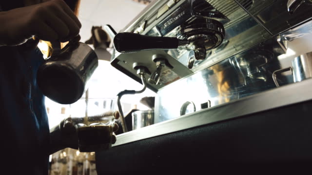 Barista-pouring-milk-into-espresso