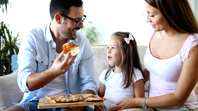 Glückliche-Familie-gemeinsam-Pizza-zu-Hause