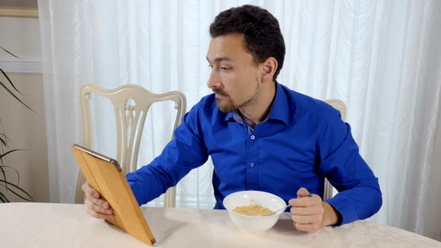 Mann-isst-Cornflakes-und-befasst-sich-mit-dem-tablet