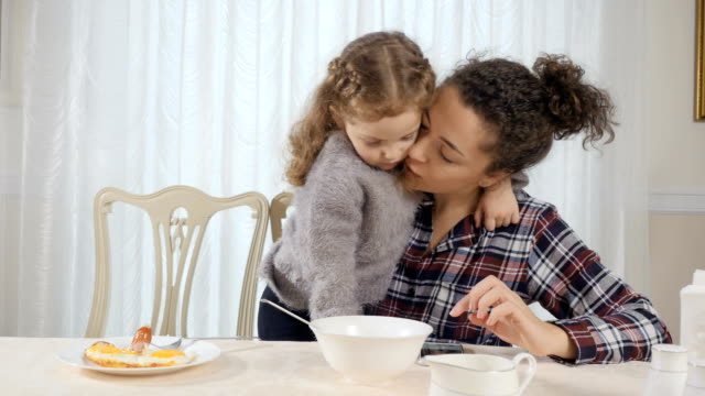 Woman-and-girl-embrace-each-other-during-breakfast