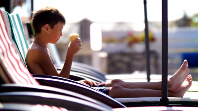 niño-comiendo-un-helado-en-una-tumbona-junto-a-la-piscina-en-el-hotel