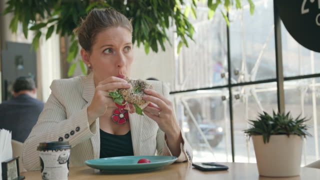 Eine-junge-Dame-im-Cafe-Sandwich-zu-essen