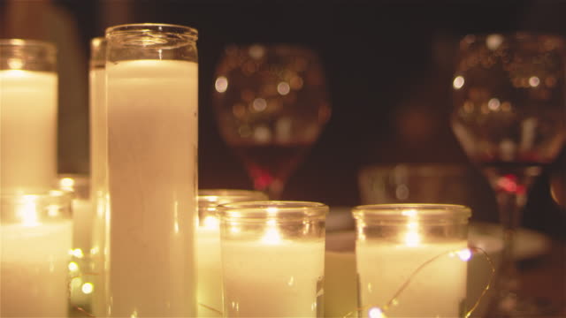 Panning-shot-of-a-patio-table-at-night-with-lit-candles