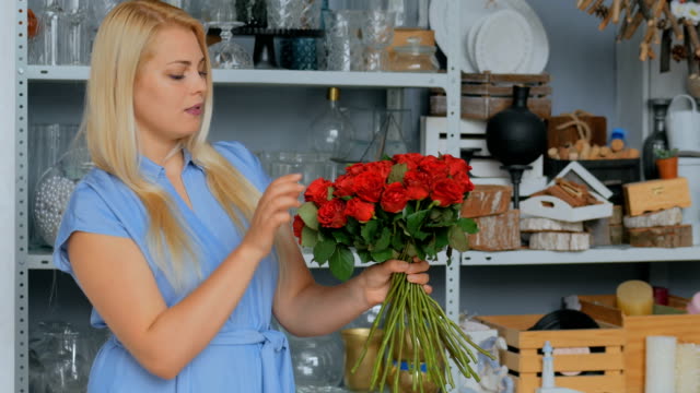 2-shots.-Professional-florist-holding-bouquet-of-red-roses-at-studio