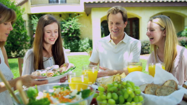 Young-family-dining-outdoors-on-healthy-organic-salad