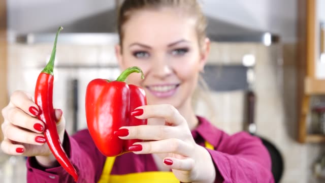 Woman-choosing-between-chilli-and-bell-pepper