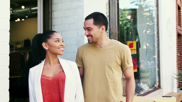 Young-Hispanic-couple-smiling-to-camera-outside-their-shop